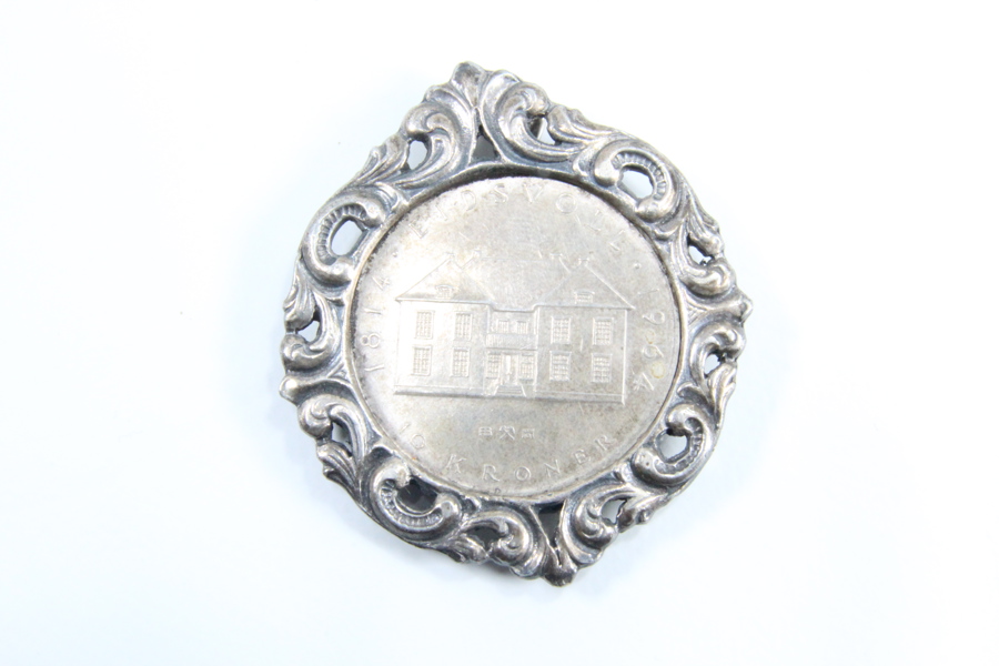 Ti krone eidsvoll i sølv laget som brosje.