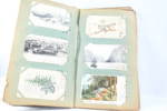 Gammelt album fylt med gamle postkort.