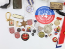Samling med diverse medaljer, pins, effekter og militær-relaterte objekter

