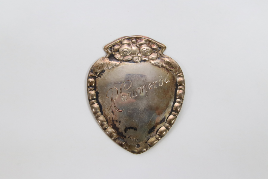 Frakkeskjold med gravering – sølv 830s, skjoldform med dekorativ topp