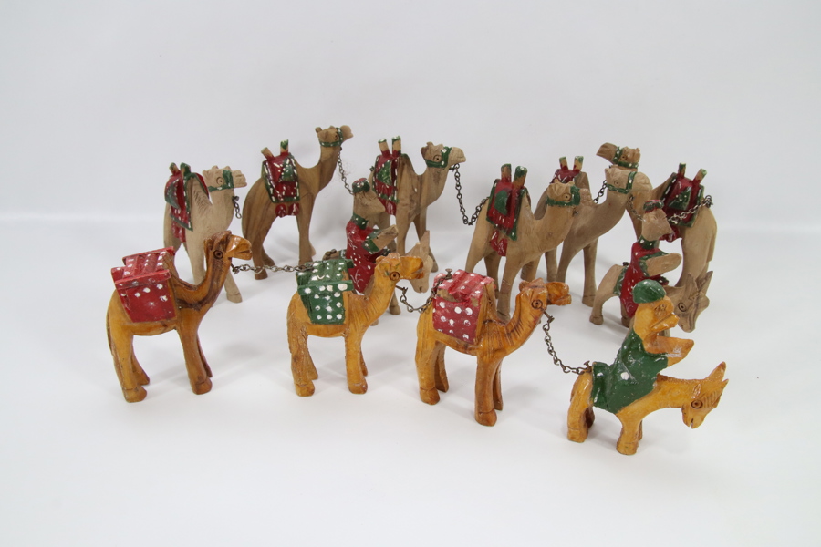 Samling håndskårne kamelfigurer i tre – 12 stk. lenket karavane
