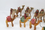 Samling håndskårne kamelfigurer i tre – 12 stk. lenket karavane
