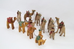 Samling håndskårne kamelfigurer i tre – 12 stk. lenket karavane
