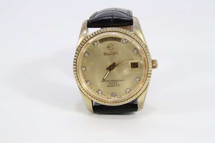 Elgin herreklokke i gulltone med dag og dato, ca. 35 mm
