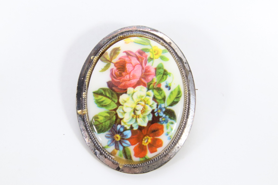 Brosje i norsk tinn med blomstermotiv
