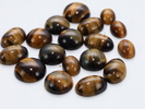 Samling cabochon-slipte tigerøye-steiner
