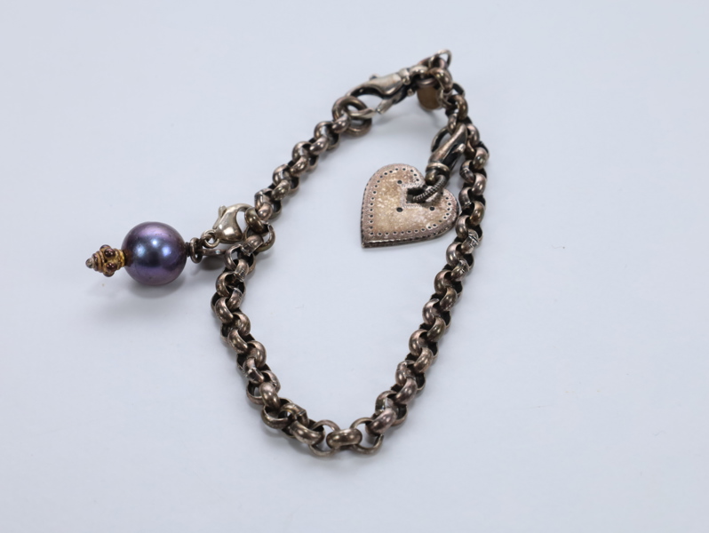 Håndlaget sølvarmbånd fra Huldresølv med to sjarms
