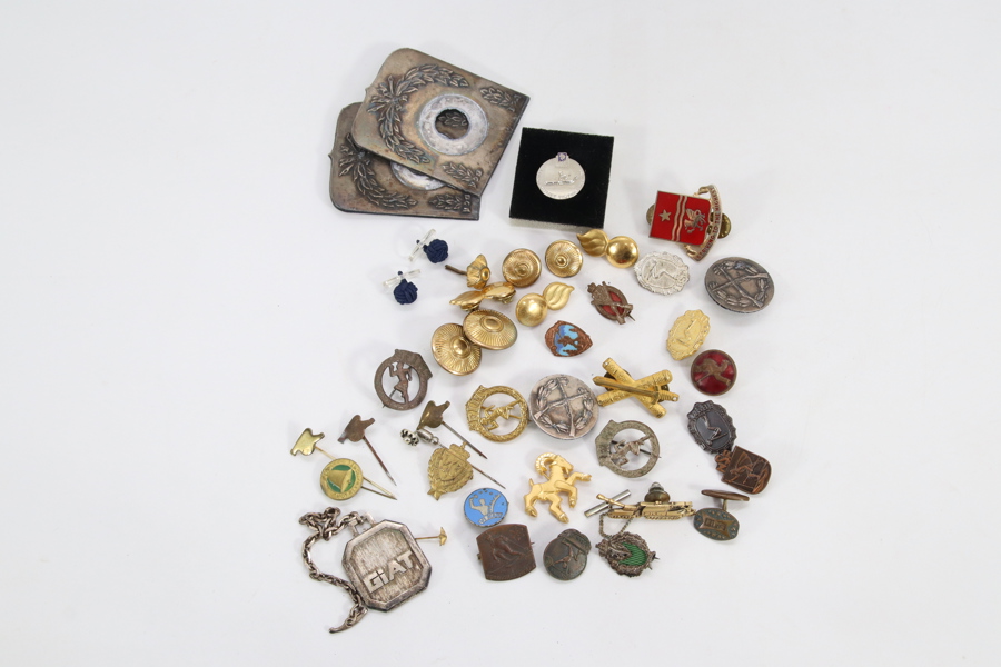 Samling diverse merker og pins i metall og emalje
