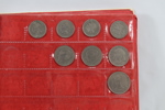 Eldre myntalbum med diverse mynter
