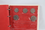 Eldre myntalbum med diverse mynter
