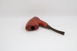 Eldre pipe med rødtonet pipehode og buet munnstykke
