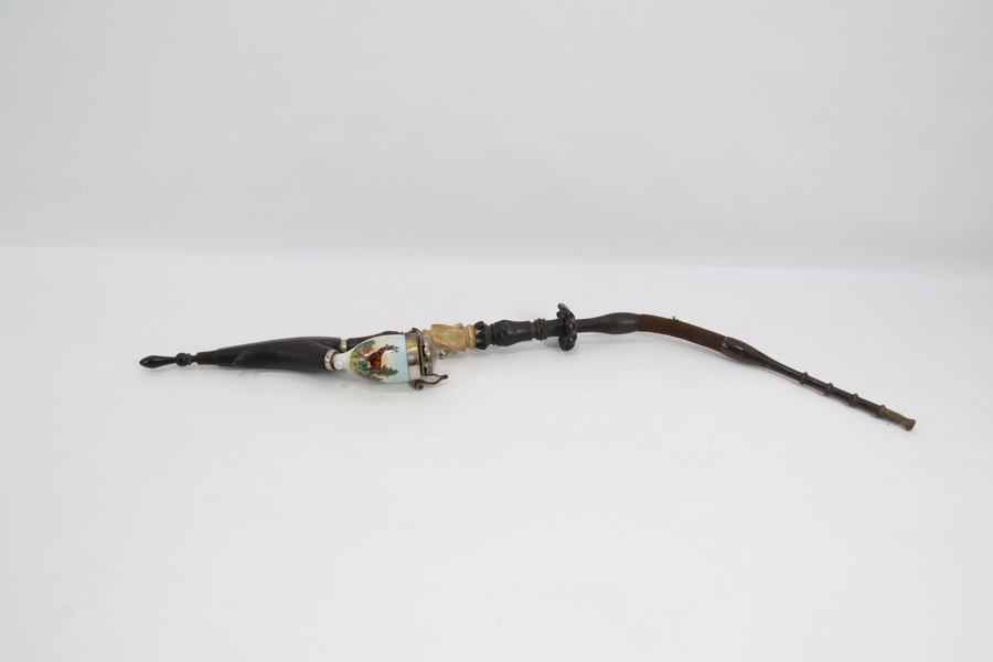 Eldre lang pipe med porselensbeholder og metallmontert lokk
