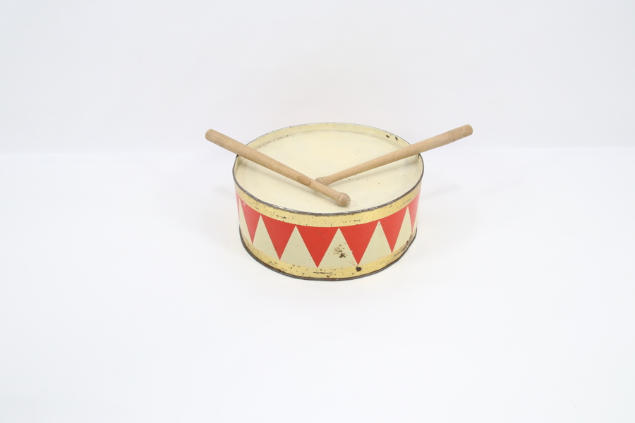 Eldre blikk-tromme med trommestikker
