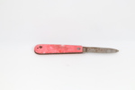 Liten eldre lommekniv med rød plastskala
