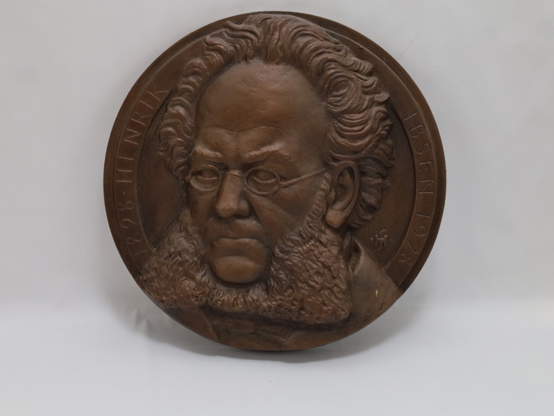 Rund relieffplakett i bronse – portrettmotiv med inskripsjon “IBSEN 1828–1906”, nummerert 276/500
