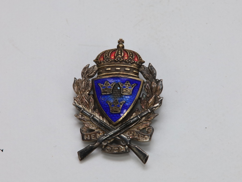 Svensk militært skyttermerke – emaljert, med korslagte geværer og riksvåpen